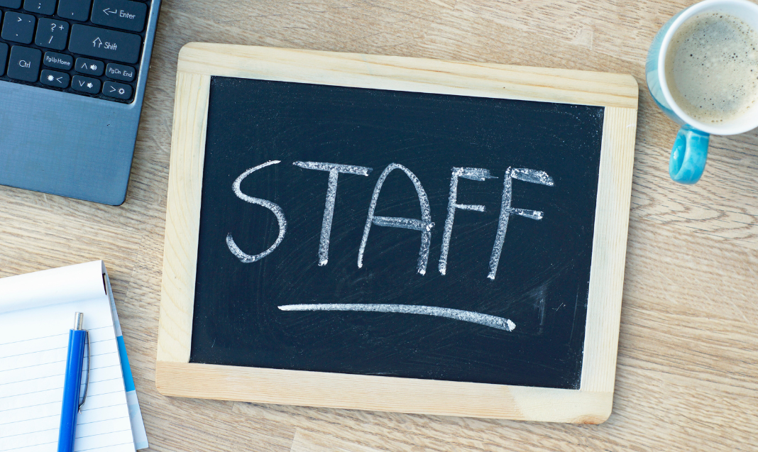 Staff, written on a chalkboard laying on a desk